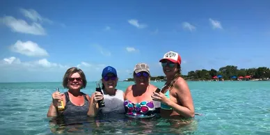 group of adults drinking beer while swimming